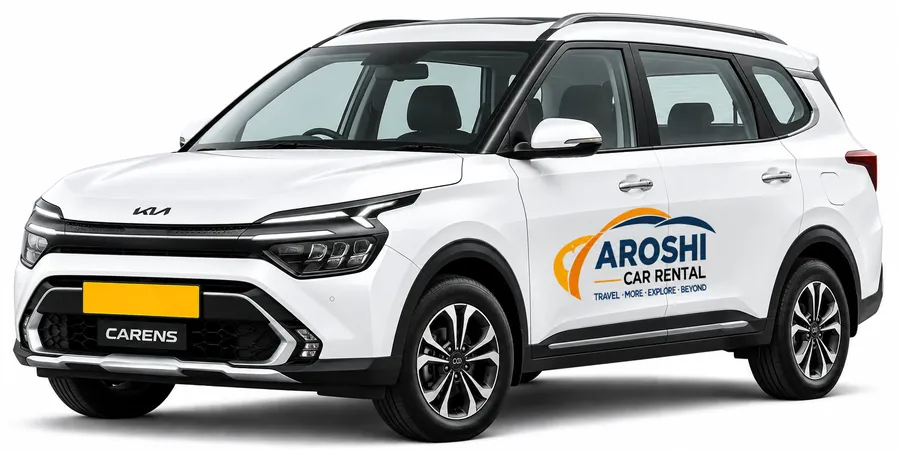 White Kia Carens 7-seater with Aroshi Car Rental branding