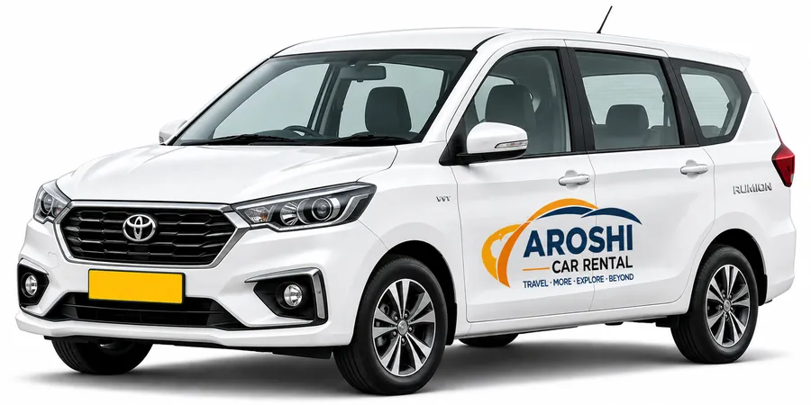 White Toyota Rumion, the Ertiga-based 7-seater MPV, with Aroshi Car Rental branding